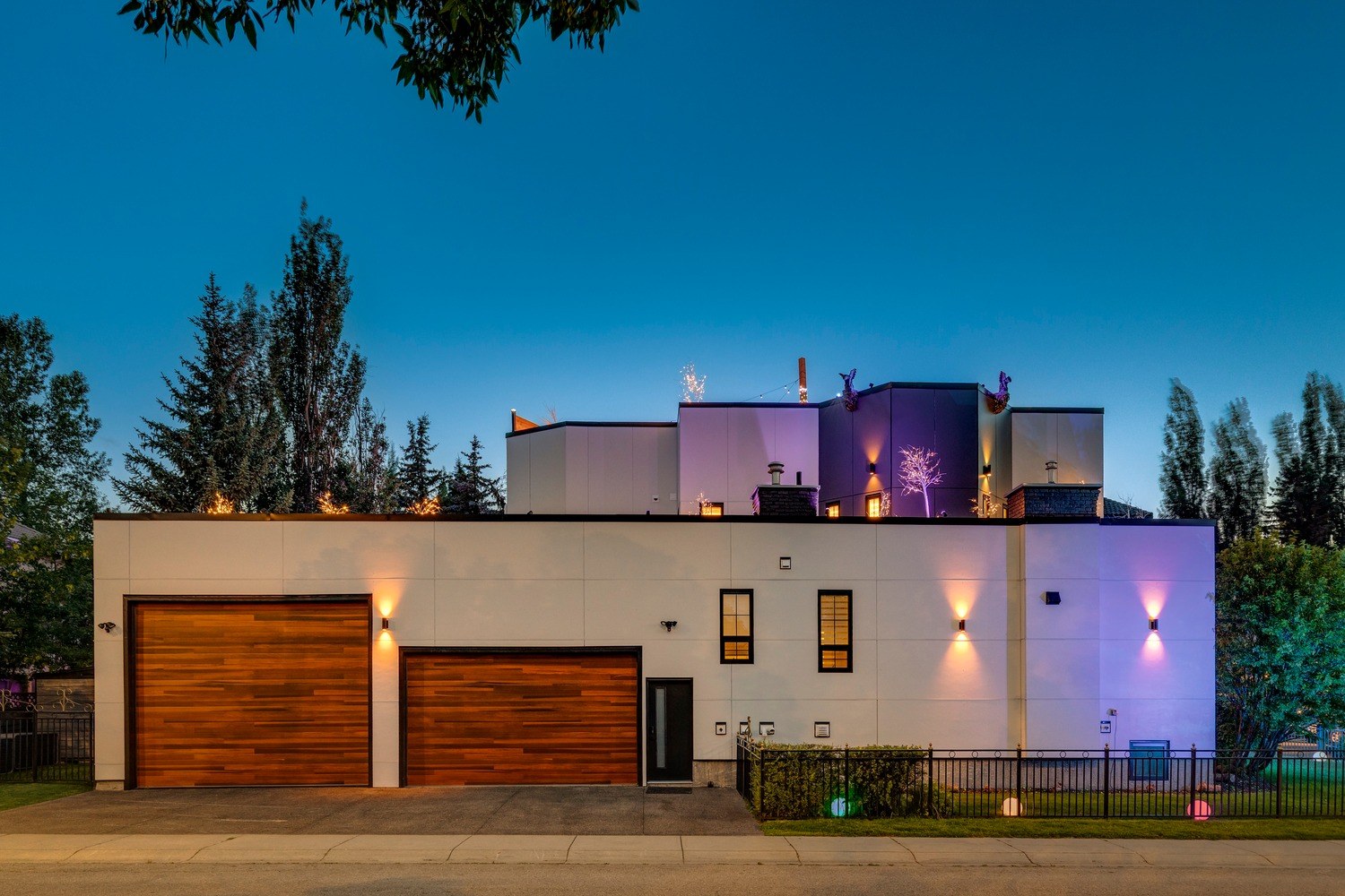 Gargoyle House at twilight — modern white exterior with warm and violet lighting